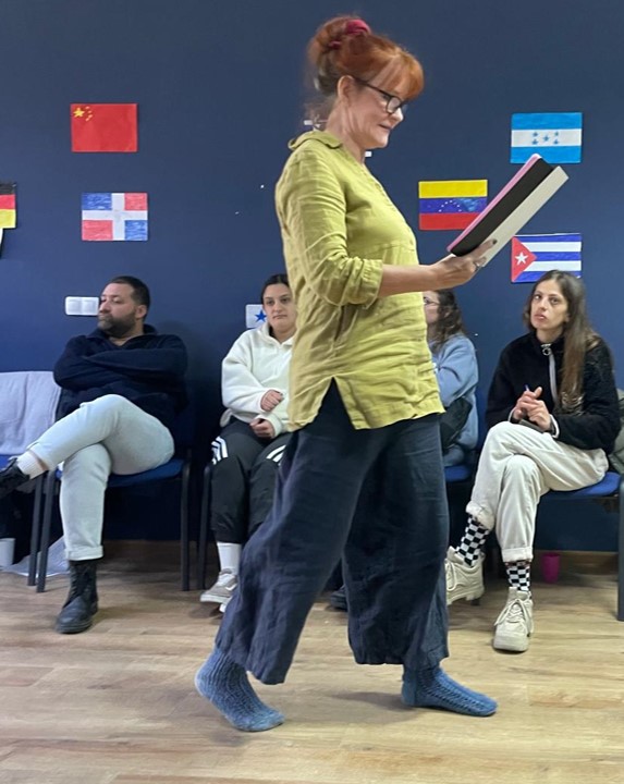 Ysi-Act project Tepi Salo. A snapshot of a conference room with young people sitting in the background and Anu walking in front.